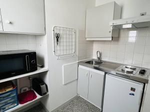 康博莱班Appartement Cambo-les-Bains, 1 pièce, 2 personnes - FR-1-495-16的小厨房配有白色橱柜和水槽