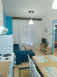 希维利Vaso Manos Apartment - Siviri Chalkidiki的厨房以及带蓝色沙发的起居室。