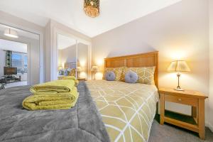 阿伯丁Kings Lodge - Grampian Lettings Ltd的一间卧室配有一张大床和一张带台灯的桌子