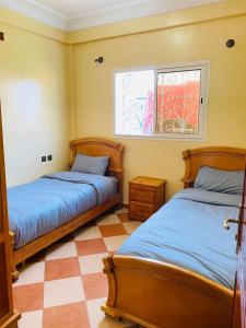 依索安Sea Surf House Imsouane的一间卧室设有两张床和窗户。