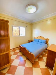 依索安Sea Surf House Imsouane的一间卧室配有一张床,铺有一个 ⁇ 板地板