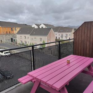 克利夫登Apt 3 The Grainstore的一张粉红色野餐长椅,坐在一个城市的阳台