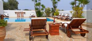 爱琴娜岛Villa Almyra的一组椅子,位于游泳池旁
