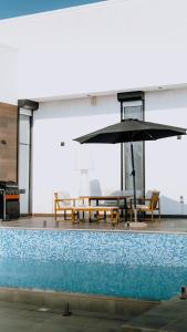 拉斯阿尔卡麦Hummingbird Rak的一个带桌子和遮阳伞的游泳池