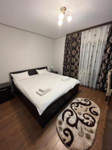 普特纳Pensiunea Miorița Putna的一间卧室配有一张大床和地毯。