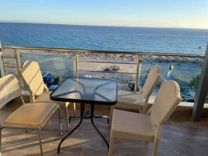 希马拉Wave n' Sea Apartments的俯瞰大海的阳台配有桌椅