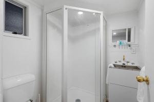 奥克兰Newly Renovated Studio w Parking - Wifi - Netflix的带淋浴和盥洗盆的白色浴室