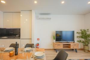 阿威罗Alameda 74 Luxury Apartment by Home Sweet Home Aveiro的一间带桌子和电视的用餐室