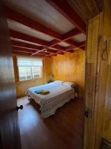 科伊艾科Cabaña la percha的木制客房内的一间卧室,配有一张床