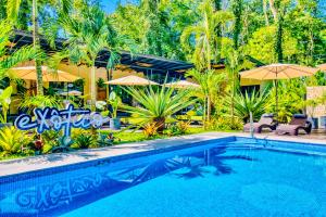 别霍港Exôtico Beach & Rooms的一个带遮阳伞的游泳池和一个度假村