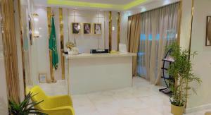 吉达Ghima Jeddah的大堂设有柜台和黄色椅子