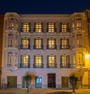 马拉加Elegante 3 dormitorios en Centro Historico Málaga的一座白色的大建筑,晚上有窗户