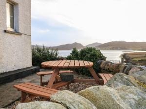 ValtosStruthan的一张木制野餐桌,享有水景