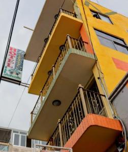 HuejotzingoHotel Carnaval的黄色的建筑,旁边设有阳台