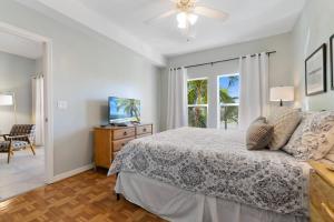 马可岛Collier Condo #202的一间卧室设有一张床、一台电视和一个窗口。