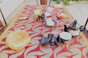 布哈拉Soliha&Yulduz Guesthouse的一张桌子,上面有餐桌布,上面有食物