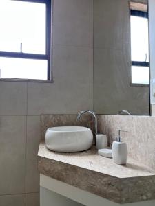 贝洛奥里藏特STUDIOS CORACAO EUCARISTICO的一间带水槽和镜子的浴室
