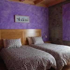 莱昂La Senra的卧室设有两张床铺和紫色墙壁