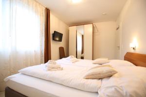 万根沃格Villa Verdi - Ferienwohnung 4的一间卧室配有两张白色的床和镜子