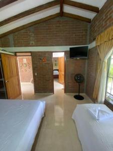 La VictoriaFINCA EL ATICO的一间卧室配有两张床和一台平面电视