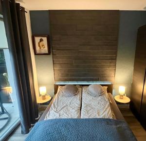 奥斯特罗达Apartament Kamila Ostróda的一间卧室配有一张带两盏灯的床。