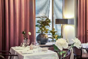 松兹瓦尔波罗的海贝斯特韦斯特酒店的用餐室配有带白色桌布的桌子,并可能使客人感到危险