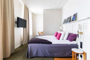 松兹瓦尔波罗的海贝斯特韦斯特酒店的一间卧室配有一张带紫色和白色枕头的床