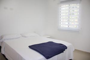 巴耶杜帕尔APARTAMENTO VALLEDUPAR的一张白色的床,上面有蓝色的毛巾