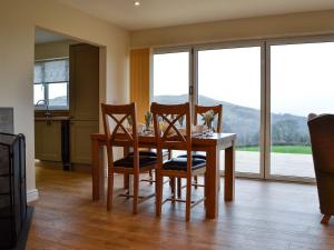 兰德林多德威尔斯Bluebell Lodge的一间带桌椅和窗户的用餐室