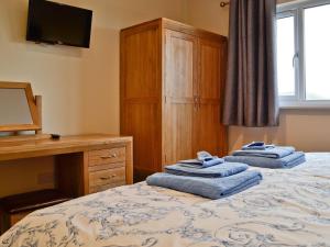 兰德林多德威尔斯Bluebell Lodge的一间卧室,床上配有2条蓝色毛巾