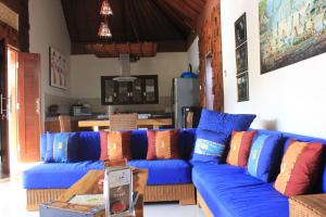 沙努尔英达2号别墅的客厅里配有带色彩缤纷枕头的蓝色沙发