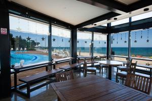 江陵市BENIKEA San&Bada Jumunjin Resort的一间带桌椅的餐厅,享有海滩美景