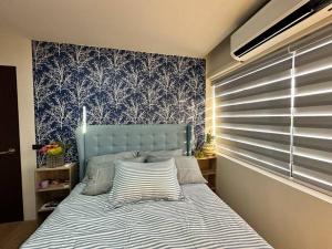 圣胡安Seafront OnCall - private jacuzzi with 4 cozy bedrooms的卧室里一张带蓝色床头板的床