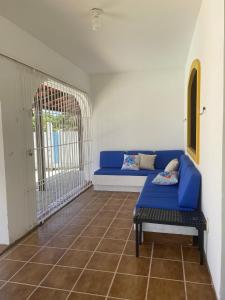 嘎林海斯港Casa temporada Porto de Galinhas bem localizada的一间设有蓝色沙发和笼子的房间