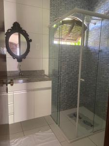嘎林海斯港Casa temporada Porto de Galinhas bem localizada的设有带镜子和水槽的淋浴的浴室