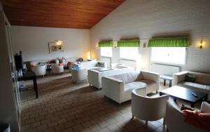 BrevikBreviken Golf & Hotell的客厅配有白色的沙发、桌子和窗户