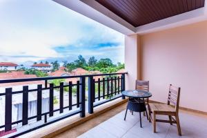 高兰Lanta Garden Hill Resort and Apartment的设有一个配有桌椅并享有美景的阳台。
