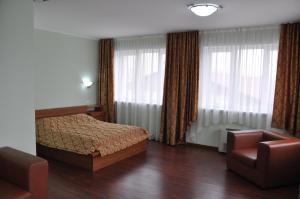 克拉斯诺亚尔斯克德芙里克酒店的一间卧室配有一张床、一把椅子和窗户。