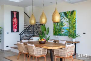 苏梅岛Jungle Beach Villa的一间带木桌和椅子的用餐室