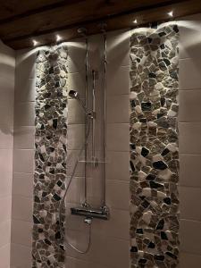 蓬卡哈尤Välituvan lomamökit的带淋浴的浴室(带石墙)