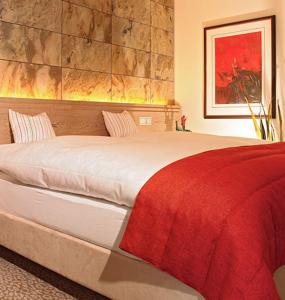 希尔兴巴赫霍夫31酒店的一间卧室配有一张带红色毯子的大床
