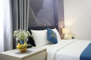 芽庄Moonlight Nha Trang Hotel的一间卧室配有一张带蓝色和白色枕头的床