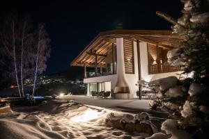 塞尔瓦迪加尔代纳山谷Chalet Villa Carolina的夜晚雪中的房子