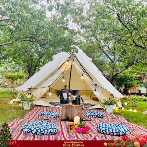 和平Caofong Glamping Village的草丛中带枕头的帐篷