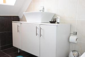 马塞卢Blue Crane Guesthouse的一间带水槽和白色橱柜的浴室