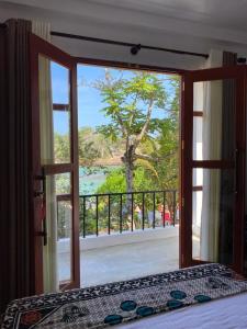 马特勒Light house beach home的卧室设有窗户,享有树木美景