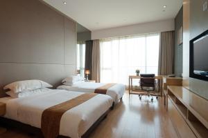 广州易成国际公寓广州琶洲保利世贸店的酒店客房设有两张床和电视。