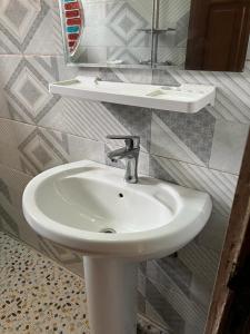 雅温得Appartement New Stading YAOUNDE - MIMBOMAN MAETURE的浴室设有白色水槽和镜子