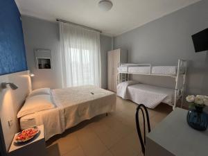 里米尼Hotel Le Ali的一间卧室配有一张床和一张双层床。