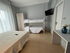 里米尼Hotel Le Ali的一间小卧室,配有一张床和一台电视